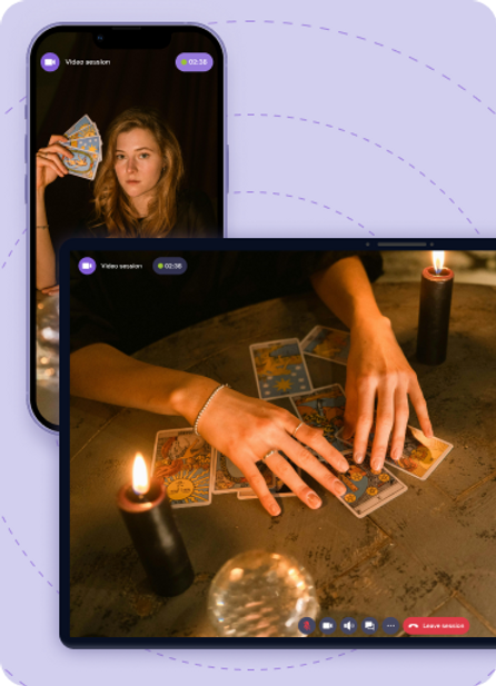 Woman holds tarot cards during a video call on a phone. Close-up of hands with cards on a table with candles and a crystal ball.