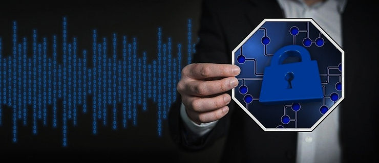 A businessman holding a glowing blue padlock icon over a stream of binary code, representing data security.