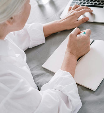 A doctor making notes while working on the computer
