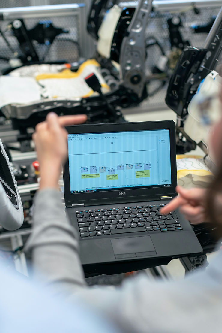Engineer checking predictive maintenance data on a digital dashboard in a factory.