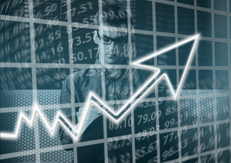 Person analyzing data on a digital screen with an upward arrow graph. Background features numbers and a gridded pattern, conveying growth.